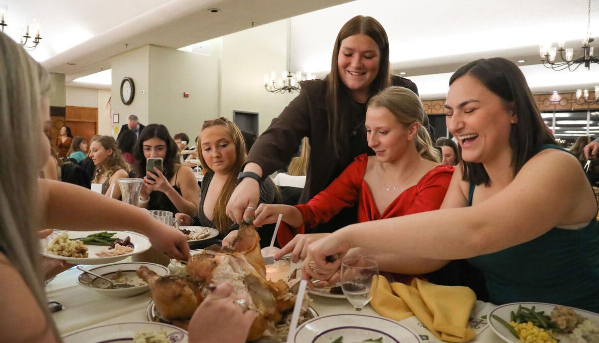 Students share some laughs as they cut into a turkey during the Holiday Banquet